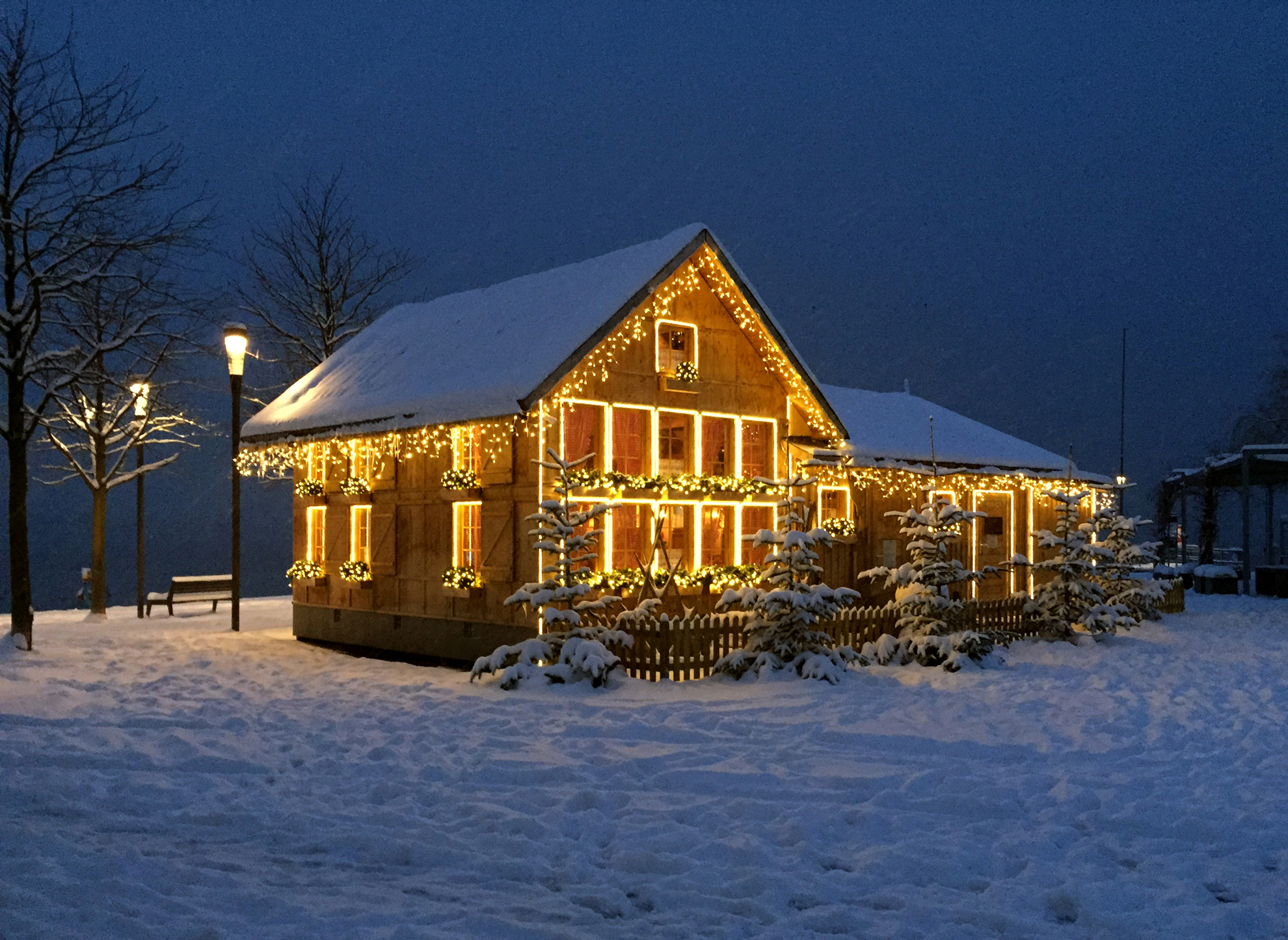 Aussenansicht des beleuchteten Appenzellerhäuschens im Schnee